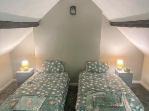 Dormitorio pequeño con 2 camas y 2 lámparas en 4c Gaia Lane en Lichfield