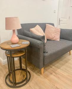 a grey couch with a table with a lamp on it at 4c Gaia Lane in Lichfield