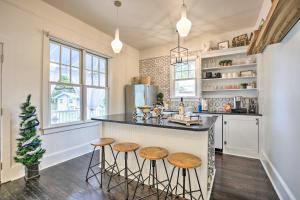 a kitchen with a counter and stools at a island at Historic 1900 Cottage in Downtown St Augustine! in Saint Augustine