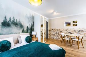 ein Schlafzimmer mit einem Bett und einem Tisch mit Stühlen in der Unterkunft Przystanek Babia Apartamenty in Lipnica Wielka