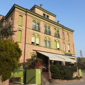 un grand bâtiment en briques avec un auvent en face dans l'établissement Da Santo Hotel Ristorante Pizzeria, à Ferrare