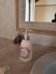 a bathroom with a soap dispenser in front of a mirror at Villa Belmonte in Tresché Conca
