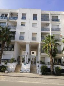 un grand bâtiment blanc avec des palmiers devant lui dans l'établissement Captivating 2-Bed Apartment in Tunis, à Tunis