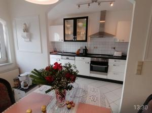 a kitchen with a table with a vase of flowers on it at Homburg in Limbach