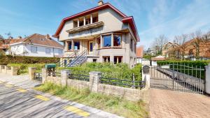 una casa con una valla delante en Villa Bella Rosa, en De Panne