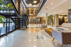 a living room with a couch and a staircase at Coliving Century Park by My Way in Porto Alegre