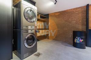 a washer and dryer in a room with a brick wall at Coliving Century Park by My Way in Porto Alegre