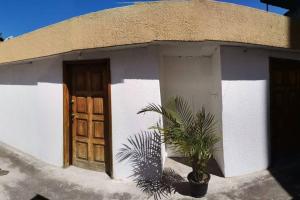 a small house with a potted plant in front of a door at Dormitorio Independiente in Quito