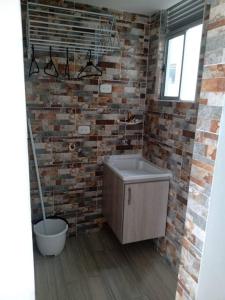 a bathroom with a brick wall and a bath tub at Hermoso apartamento Ricaurte in Ricaurte