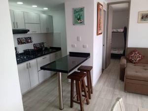 a kitchen with a table and chairs and a couch at Hermoso apartamento Ricaurte in Ricaurte