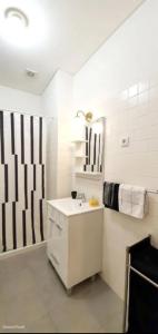 een witte badkamer met een wastafel en een douche bij Dom Luis apartment in Porto