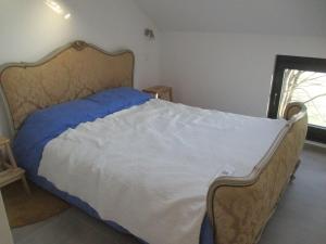 um quarto com uma cama grande e uma cabeceira em madeira em l'abri'gîte sous les arbres em Huy