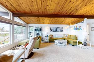 a living room with a wooden ceiling at Patty's Sea Perch in Yachats