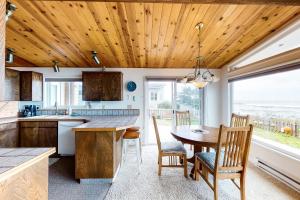 a kitchen with a wooden ceiling and a table and chairs at Patty's Sea Perch in Yachats
