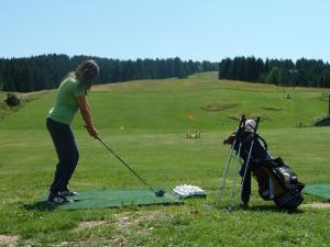 uma mulher a jogar golfe num campo de golfe em Albergo Miramonti Dependance em Asiago