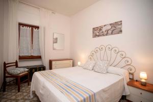 um quarto com uma cama branca e uma janela em Ortensia e Glicine - Goelba em Seccheto