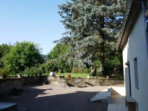 un patio con tavolo, sedie e un albero di Chambre d'Aut' ad Autun