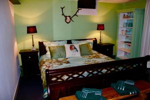 een slaapkamer met een bed met 2 tafels en 2 lampen bij B&B Woudzicht Groesbeek in Groesbeek