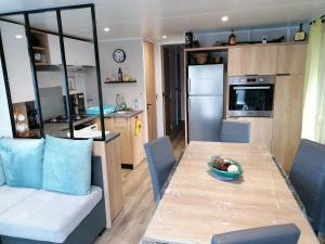 加斯泰Les Pins del Sol - camping la réserve的厨房以及带碗的桌子的用餐室。
