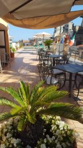 a patio with tables and chairs and a palm tree at Hotel Santa Lucia in Minori