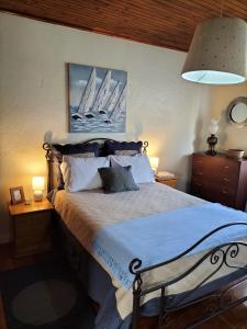 a bedroom with a bed with two night stands and two lamps at Porto Pim Beach House in Horta