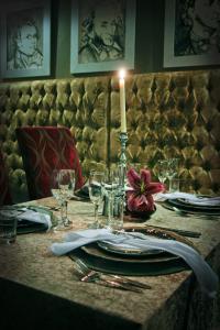 una mesa con una vela, platos y copas de vino en Altissimo Guesthouse, en Bloemfontein
