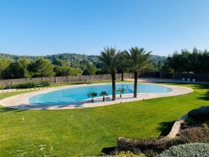 ein Swimmingpool in einem Garten mit Palmen in der Unterkunft Naranjo golf & leisure in Orihuela