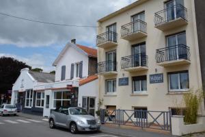 a car parked in front of a building at Logis Le Petit Trianon in Saint-Brevin-les-Pins