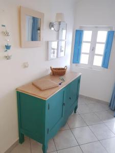 a blue cabinet in a room with two windows at Blue4u in Imerovigli