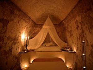 a bed with a canopy in a room at Suites of the Gods Cave Spa Hotel in Megalokhori