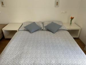 a bed with two pillows on it with two tables at Apartmán pri Dierach in Terchová