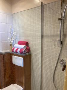 a bathroom with a shower and a toilet and towels at Pendora Appartements in Mindelo