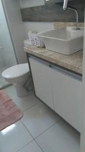 a white bathroom with a sink and a toilet at Apartamento aconchegante em Bento Gonçalves, próximo ao vale dos vinhedos in Bento Gonçalves +24 photos