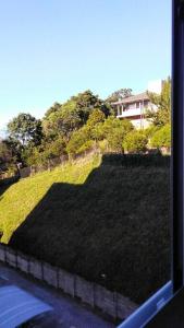 a view of a grassy hill from a window at Apartamento aconchegante em Bento Gonçalves, próximo ao vale dos vinhedos in Bento Gonçalves