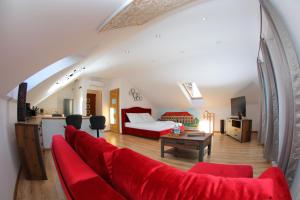 a living room with a red couch and a bed at Apartament Książęcy klimatyzacja in Żagań