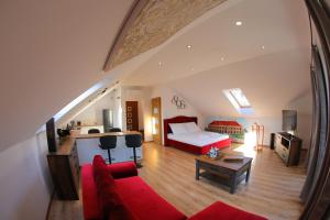 a living room with a red couch and a bed at Apartament Książęcy klimatyzacja in Żagań