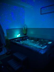a jacuzzi tub in a dark room with stars at Bohème Spa Appartement privatif avec jacuzzi in Orléans