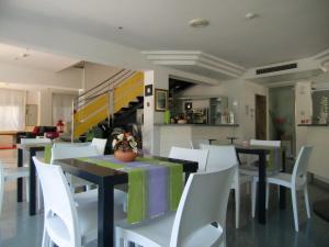 una sala da pranzo con tavoli e sedie bianche di Hotel Desire' a Riccione