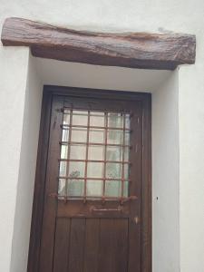 une porte en bois avec une fenêtre au-dessus de celle-ci dans l'établissement Antica Fonni, à Fonni