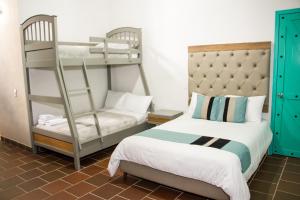 a bedroom with two bunk beds and a chair at Hotel Mesa De Los Santos in Los Curos
