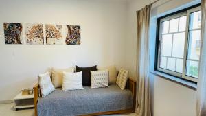 a bedroom with a bed with pillows and a window at Bicos 101 by Check-in Portugal in Albufeira