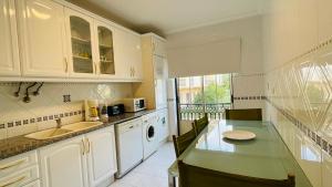a kitchen with white cabinets and a green counter top at Bicos 101 by Check-in Portugal in Albufeira +25 photos
