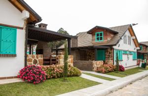 Los CurosHotel Mesa De Los Santos的院子里有绿门和鲜花的房子