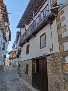 un edificio en un callejón con una puerta de madera en El Cascanueces - Casa Rural en Candelario