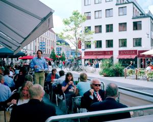 a group of people sitting at an outdoor restaurant at DA Hotel Apartments in Gothenburg