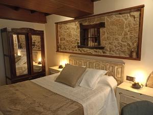 sypialnia z łóżkiem i kamienną ścianą w obiekcie El Cascanueces - Casa Rural w mieście Candelario