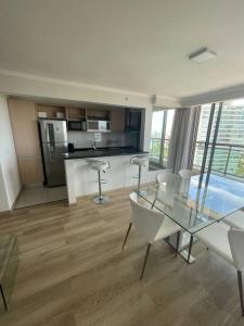 a kitchen with a glass table and chairs in a room at Edif. Place Lafayett Piso 19, 3 dormitorios y excelentes amenities in Punta del Este