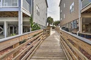 a wooden walkway between two buildings at Ocean Club Condo with Community Pool and Hot Tub in Salter Path