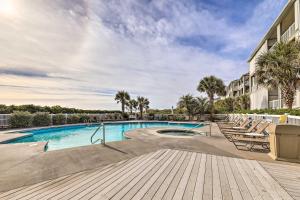a swimming pool at a resort with lounge chairs at Ocean Club Condo with Community Pool and Hot Tub in Salter Path