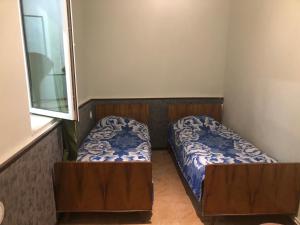 a small room with two beds and a window at Metax House Yerevan in Yerevan